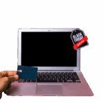 hand-with-credit-card-near-laptop-with-sign